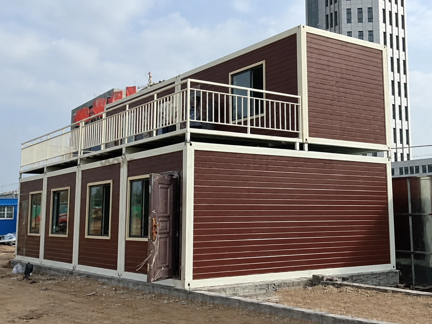 Edifício modular de dois andares com revestimento horizontal marrom e passarela externa superior no projeto da Tailândia